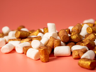 Mini marshmallows on a pink background. Marshmallow gold and white.