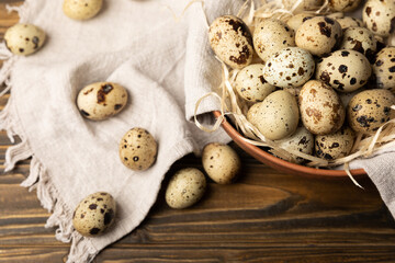 Quail eggs in a plate on a dark old brown wooden background. Eco product. Diet food. Healthy food. Space for text.Space for copy.