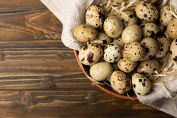 Quail eggs in a plate on a dark old brown wooden background. Eco product. Diet food. Healthy food. Space for text.Space for copy.