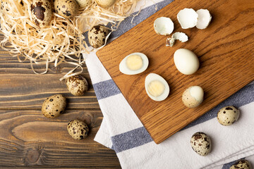 Boiled quail egg on a cutting board. Composition on a brown wooden table. Healthy food. Top view. place to copy.