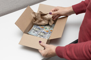 a man holds a box in which dollars.