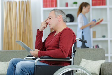 elderly man on wheelchair reading on the tablet
