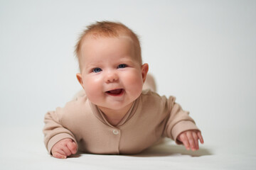 portrait of an infant lying with a cheerful emotion on a white background