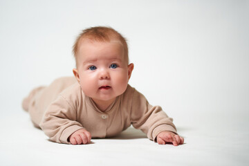 portrait of an infant learning to crawl against a white background