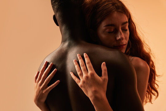 Sensual couple embracing near pink background