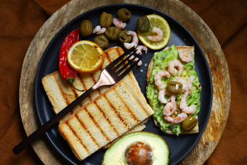 Guacamole toast with avocado, shrimp and olives. Healthy snack. Keto.