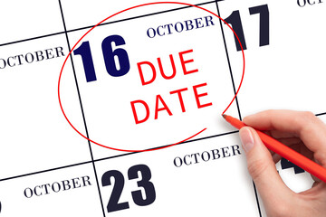 16th day of October. Hand writing text DUE DATE on calendar date October 16 and circling it. Payment due date. Business concept. Autumn month, day of the year concept.