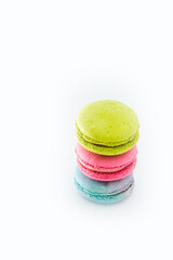 Brightly colored stacked up macarons on white. Tasty colourful macaroons. Blue, pink and green macaroons isolated on white background. French pastry made from egg whites. Concept of food, desserts
