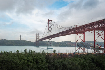 25 de Abril Bridge, Sanctuary of Christ the King skyline and Tagus River (Rio Tejo) - Lisbon, Portugal