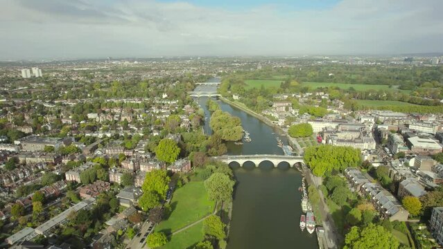 The drone aerial footage of Thames River runs through Richmond town center on the east bank with its neighboring district of East Twickenham to the west, London, UK.