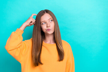 Closeup portrait of young beautiful girl scratch head minded looking empty space pouted lips hmm hard choice isolated on cyan color background