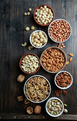 Nuts variety in the bowls - cashew, hazelnut, macadamia, pistachio, almond, walnut, peanut, pecan