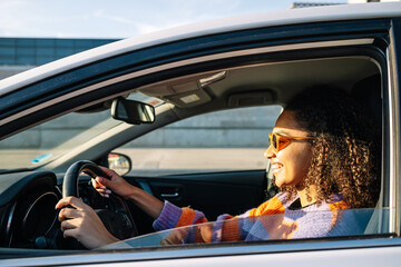 Portrait of smiling young african american woman driving a car