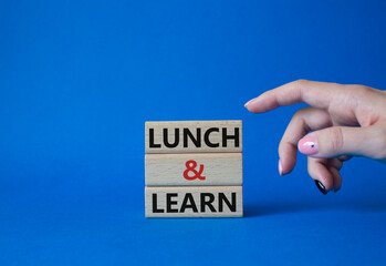 Lunch and learn symbol. Concept words Lunch and learn on wooden blocks. Beautiful blue background....