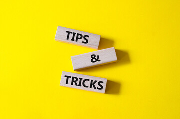 Tips and tricks symbol. Wooden blocks with words Tips and tricks. Beautiful yellow background....