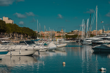 Fototapeta na wymiar Marina in Valletta, Malta on a summer day. Visible multitude of boats and yachts with some buildings in the background.