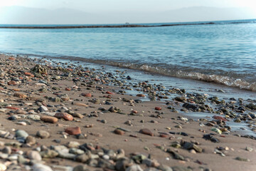 Rocks on the beach with wavey blue ocean, close up