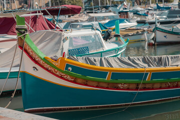 Fototapeta na wymiar Luzzu, a typical boat of Malta moored in the marina of Valletta