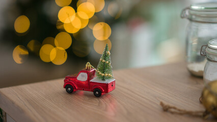 New Year's toy in the form of a car with a Christmas tree. Christmas toy on the background of Christmas lights.