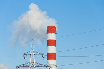 The pipe of the industrial plant emits toxic smoke into the atmosphere and air. Pollution of the environment and ecology. Thermal power plant power lines high voltage