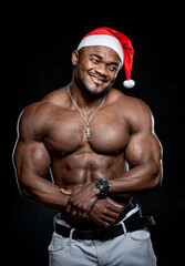 Obraz na płótnie Canvas New year muscular young man portrait. Bodybuilder sexy male in christmas hat.