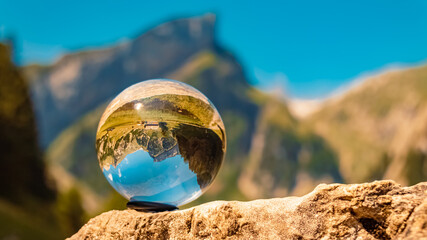 Crystal ball alpine summer landscape shot at the famous Seealpsee lake, Appenzell, Alpstein, Switzerland