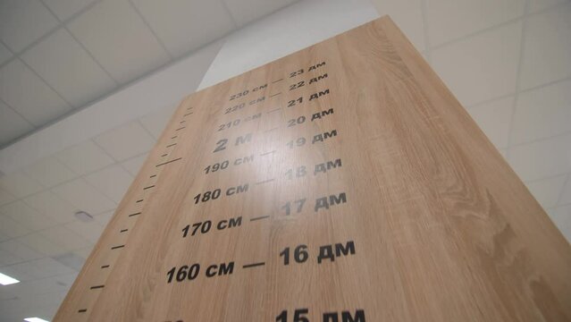 Wooden panel for height measurement with scale on column at school closeup. Equipment for students development