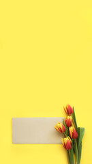 brown envelope and red flowers tulips on yellow background, vertical, 16:9