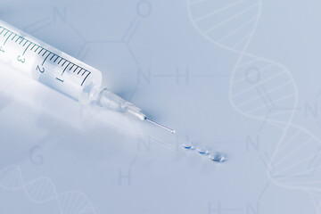 Syringe with injection over blue background. Vaccination or beauty therapy concept.