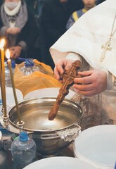 Consecration of water with a wooden cross in church