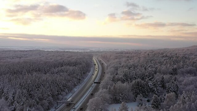 Aerial video view from drone of a Sunrise over snowy winter road. Germany 