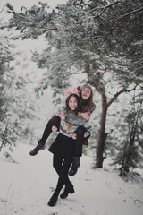 Fototapeta na wymiar Close up fashion portrait of two sisters hugs and having fun winter time,wearing pink hats, rabbit ears and sweater,best friends couple outdoors, snowy weather