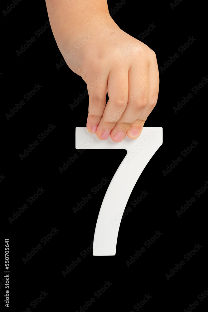 Aufkleber Number seven in hand isolated on black background. Number 7 in a child's hand on a black background. To be inserted into a project or design.