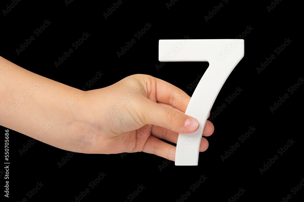 Aufkleber number seven in hand isolated on black background. number 7 in a child's hand on a black background.