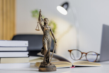 statuette of Themis, the goddess of justice, stands on a table in the office of a law firm or attorney. legal advice online on the Internet. defense in court, verification of legal contracts and work