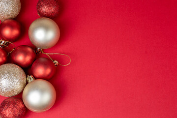 Red and golden christmas balls on red background with copy space top view, template for postcards, banner.