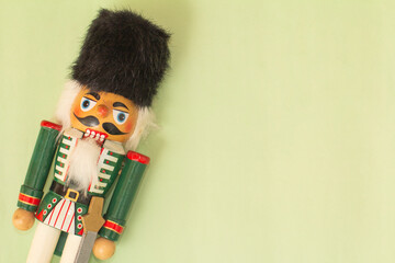 Interesting beautiful christmas nutcracker soldier on green colored paper surface texture with copy...