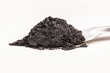 black pigment, powder for industrial or cosmetic use, isolated white background, in petri dish