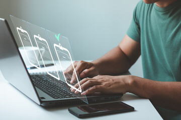 Man hand using a laptop computer with a virtual screen and document for online approval paperless...