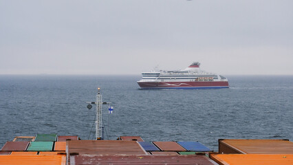 Baltic sea, Europe - 10 11 2022: Container vessel at anchor off the Finnish coast and passenger ferry crossing her bow. © I am from Mykolayiv