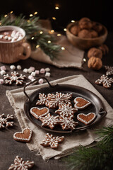 Hand made christmas gingerbread cookies with decoration and hot chocolate with marshmallows