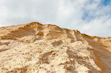 sand quarry, in the photo sand mountain in the quarry in the background blue sky and clouds bottom...