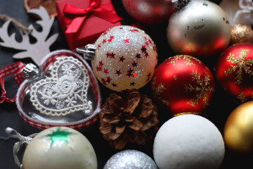 Fototapeta na wymiar Various colorful Christmas ornaments on dark background, selective focus.