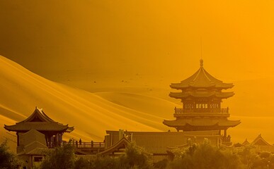 Breathtaking scenery of the crescentic moon lake temple against the silky desert hills in China
