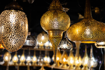 Bright openwork hanging metal lamps of an unusual shape - obrazy, fototapety, plakaty
