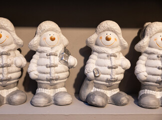 Small toy snowmen stand on a shelf for sale
