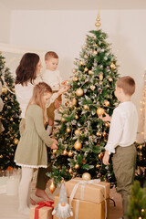 Family with many children decorates the tree. Family at the Christmas tree. Christmas spirit in Germany