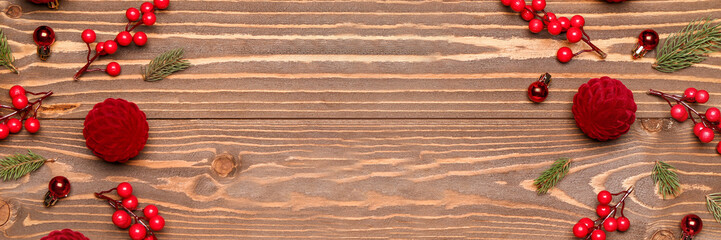 Christmas balls, fir branches and berries on wooden background with space for text