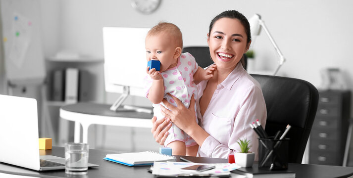 Working mother with her little baby in office