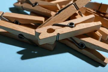 Heap of wooden clothespins on blue background, closeup